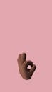 3D-rendered hand making an OK gesture on a soft pink background.